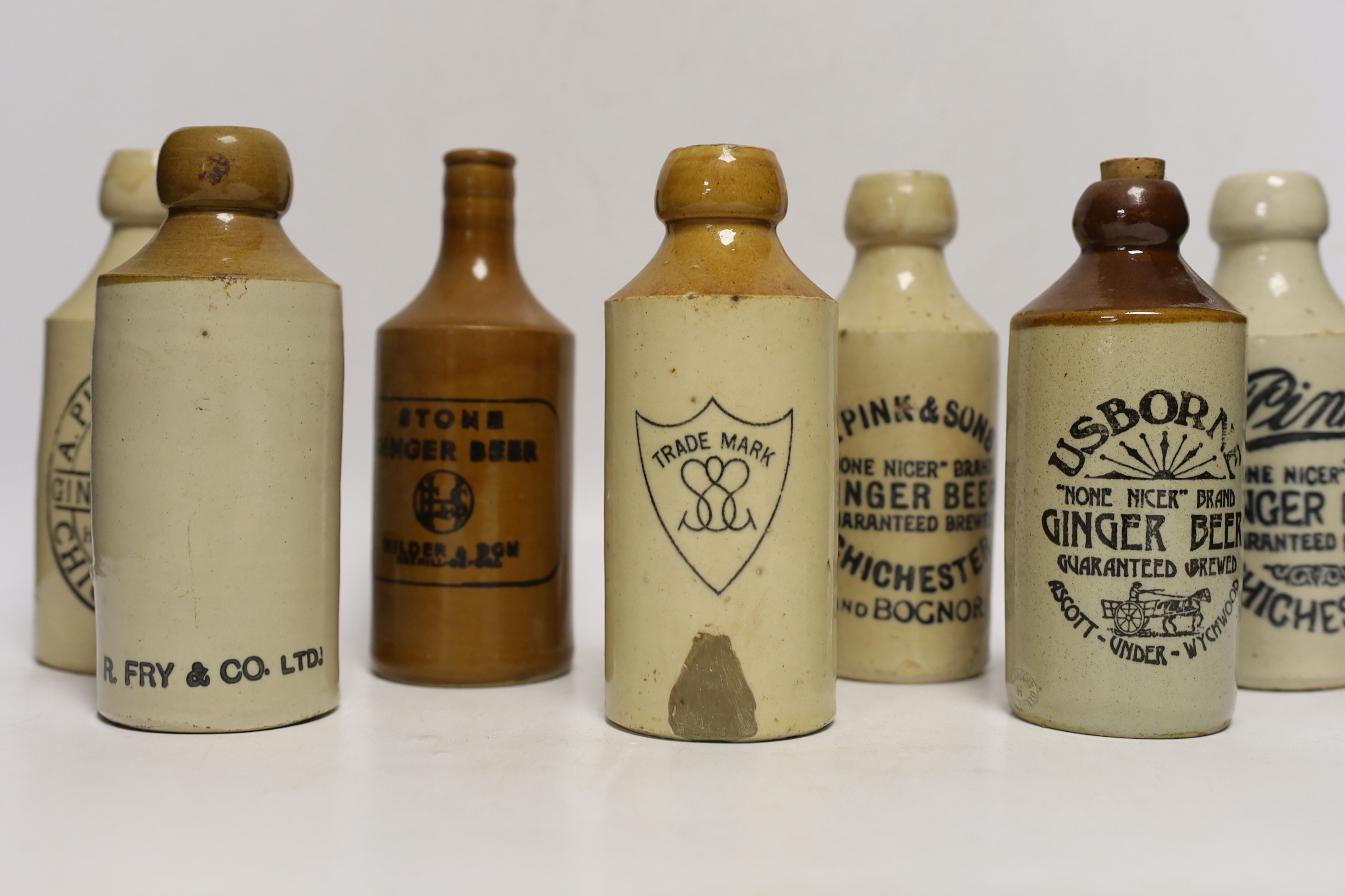Early 20th century stoneware ginger beer bottles, six from Chichester and four others